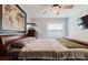 This bedroom features light wood floors, a modern ceiling fan, and a dresser with an aquarium at 7404 Bay Dr, Tampa, FL 33635