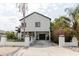 Modern two-story home featuring a gated driveway, lush landscaping, and an inviting facade at 7404 Bay Dr, Tampa, FL 33635