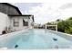 A hot tub with the house in the background, with a patio and trees at 7404 Bay Dr, Tampa, FL 33635