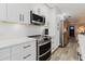 Stylish kitchen featuring white cabinets, subway tile backsplash, and modern appliances, perfect for culinary enthusiasts at 7404 Bay Dr, Tampa, FL 33635