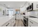 Bright kitchen with white cabinets, an island, and stainless steel appliances, creating an inviting and efficient workspace at 7404 Bay Dr, Tampa, FL 33635