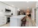 Open kitchen with stainless steel appliances, white cabinetry, island with seating, and open to living area at 7404 Bay Dr, Tampa, FL 33635