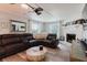 Cozy living room featuring a stone fireplace, leather sectional, and wood-style flooring at 7404 Bay Dr, Tampa, FL 33635
