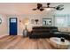 Cozy living room featuring wood floors, a comfortable leather sofa, and a stylish blue door at 7404 Bay Dr, Tampa, FL 33635