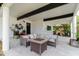Covered outdoor patio showcasing comfortable seating around a stylish table with a stone accent wall at 7404 Bay Dr, Tampa, FL 33635