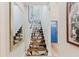 Stairway features decorative stair runners, white walls, a mirror, and a blue door at 7404 Bay Dr, Tampa, FL 33635