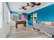 Spacious sun room with tiled floors, bright blue walls, and a ceiling fan at 7404 Bay Dr, Tampa, FL 33635