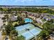 Community aerial view showcases tennis courts, a large pool, and surrounding residential streets at 7699 Windchase Way, Wesley Chapel, FL 33545