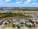 Beautiful aerial view of community, with water, pool, tennis courts, walking trails, and landscaping at 7699 Windchase Way, Wesley Chapel, FL 33545