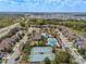 Community aerial view showcasing a pool, tennis courts, landscaping, and residential streets at 7699 Windchase Way, Wesley Chapel, FL 33545