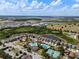 Community aerial view of a pool, tennis court, lake, and walking trails at 7699 Windchase Way, Wesley Chapel, FL 33545
