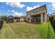 Spacious backyard with lush lawn, screened patio, and fenced pool, perfect for outdoor enjoyment at 7699 Windchase Way, Wesley Chapel, FL 33545