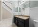 Bathroom featuring granite counters, dark cabinetry and white paneling at 7699 Windchase Way, Wesley Chapel, FL 33545