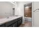 Well-lit bathroom with a double sink vanity, large mirror, and a shower-tub combo with brown tile at 7699 Windchase Way, Wesley Chapel, FL 33545