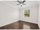 Cozy bedroom featuring dark hardwood flooring, a ceiling fan, and a window with natural light at 7699 Windchase Way, Wesley Chapel, FL 33545