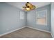 Inviting bedroom with a ceiling fan and two windows for natural light, offering a relaxing space at 7699 Windchase Way, Wesley Chapel, FL 33545