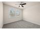 Bright bedroom featuring neutral carpet, a ceiling fan, and a window with scenic views at 7699 Windchase Way, Wesley Chapel, FL 33545