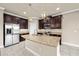Spacious kitchen featuring a central island with granite countertops, stainless steel appliances, and dark cabinetry at 7699 Windchase Way, Wesley Chapel, FL 33545
