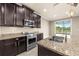 Gourmet kitchen featuring granite counters, stainless appliances, and a sink overlooking a scenic lake view at 7699 Windchase Way, Wesley Chapel, FL 33545