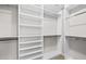 Walk-in closet featuring custom shelving and hanging rods for maximum storage at 7699 Windchase Way, Wesley Chapel, FL 33545