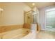 Bathroom showcasing a soaking tub, glass enclosed shower, and tile flooring at 7901 Seminole Blvd # 1103, Seminole, FL 33772