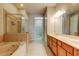 Primary bathroom with a soaking tub, glass enclosed shower, tile flooring, and a dual sink vanity at 7901 Seminole Blvd # 1103, Seminole, FL 33772