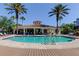 Community pool featuring palm trees and a cabana with seating areas at 7901 Seminole Blvd # 1103, Seminole, FL 33772