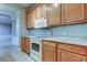 Well-lit kitchen featuring an oven, microwave, upper and lower wooden cabinets, and light countertops at 7901 Seminole Blvd # 1103, Seminole, FL 33772