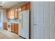 Bright kitchen with wooden cabinets, a white refrigerator, a microwave, and neutral countertops at 7901 Seminole Blvd # 1103, Seminole, FL 33772