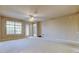Large, empty living room featuring a ceiling fan and access to a balcony at 7901 Seminole Blvd # 1103, Seminole, FL 33772