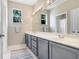Bathroom with double sinks, gray cabinets, white countertops, and large vanity mirror at 808 Hickory Glen Dr, Seffner, FL 33584