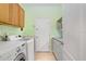Well-lit laundry room boasts upper and lower cabinetry, sink and modern washer and dryer at 808 Hickory Glen Dr, Seffner, FL 33584