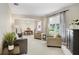 Open-concept living room with ample seating, neutral colors, and natural light from large windows at 808 Hickory Glen Dr, Seffner, FL 33584
