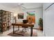 Well-lit home office with a large wooden desk, a bookshelf, a ceiling fan and an area rug at 808 Hickory Glen Dr, Seffner, FL 33584
