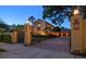 Elegant, gated home with a brick driveway, mature landscaping, and warm exterior lighting at dusk at 843 17Th N Ave, St Petersburg, FL 33704