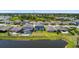 Aerial view showcasing a home with a screened-in pool and backyard overlooking a tranquil pond at 8595 Prairie Creek Dr, New Port Richey, FL 34655