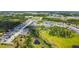 Panoramic aerial view of a residential area with houses, a pond, green spaces, and community amenities at 8595 Prairie Creek Dr, New Port Richey, FL 34655