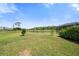 Wide backyard with lush lawn and pond view, perfect for enjoying nature and outdoor activities at 8595 Prairie Creek Dr, New Port Richey, FL 34655