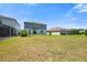 Expansive backyard with verdant lawn complements the modern two-story home and screened in pool at 8595 Prairie Creek Dr, New Port Richey, FL 34655