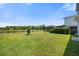 Expansive backyard featuring a pond view, lush lawn, and screened-in lanai for outdoor living at 8595 Prairie Creek Dr, New Port Richey, FL 34655