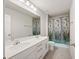 The bathroom features a double sink vanity and a shower-tub combination with colorful curtain at 8595 Prairie Creek Dr, New Port Richey, FL 34655