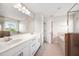 Bathroom featuring a double vanity, large mirror, and a separate tub and shower area at 8595 Prairie Creek Dr, New Port Richey, FL 34655