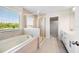 Bright bathroom showcasing a soaking tub, glass-enclosed shower, and a window with natural light at 8595 Prairie Creek Dr, New Port Richey, FL 34655