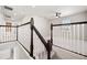 Bright hallway features dark wood railing and white spindles leading to the upper level at 8595 Prairie Creek Dr, New Port Richey, FL 34655