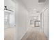 Bright hallway leads to bedrooms with neutral carpeting, white walls and trim and black wrought iron railing at 8595 Prairie Creek Dr, New Port Richey, FL 34655