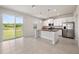Open-concept kitchen with stainless steel appliances and granite countertops offers views of backyard at 8595 Prairie Creek Dr, New Port Richey, FL 34655