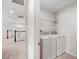 Well lit laundry room features modern washer and dryer, along with wire shelving for storage at 8595 Prairie Creek Dr, New Port Richey, FL 34655