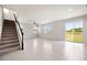 Spacious living room with staircase and natural light from sliding glass doors at 8595 Prairie Creek Dr, New Port Richey, FL 34655