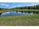 Picturesque pond with sky reflections, framed by a well-maintained green lawn at 8595 Prairie Creek Dr, New Port Richey, FL 34655