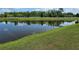 Scenic pond view with lush green surroundings and a white fence backdrop on a sunny day at 8595 Prairie Creek Dr, New Port Richey, FL 34655